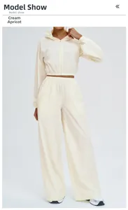 Detail shot of woman wearing cream apricot hooded sports jacket and wide-leg pants
