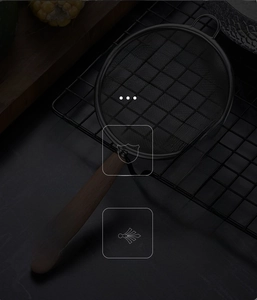 Close-up of stainless steel fine mesh strainer with solid wood handle and hanging hole