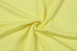Gros plan sur la maille fine jaune clair avec un drapé en spirale élégant et doux