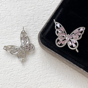 Dettaglio di ciondoli a farfalla in argento con zirconi rosa per creazione di gioielli DIY