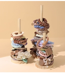 Detail view of colorful hair accessories on solid wood scrunchie display stands