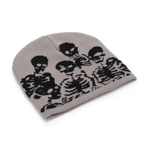 Detailed knit texture of a grey beanie with black skull and bone embroidery