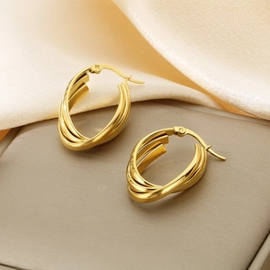 Detailed view of gold triple layered hoop earrings on soft velvet and leather display