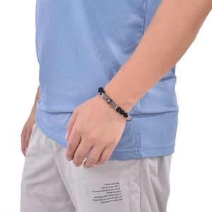 Close-up of a minimalist men's beaded bracelet featuring black and gray stone beads on a wrist