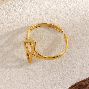 Macro shot of 18K gold plated stainless steel star-shaped open ring on textured surface