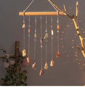 Detail of natural crystal stones hanging on a wooden stick dreamcatcher wind chime