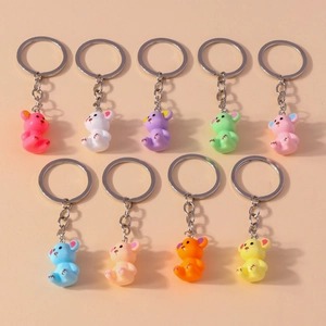 Detailed flat lay of nine colorful resin bear keychains in pink, purple, green, and blue