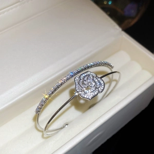 Macro view of silver-tone double-layered open bangle with pavé zircon flower