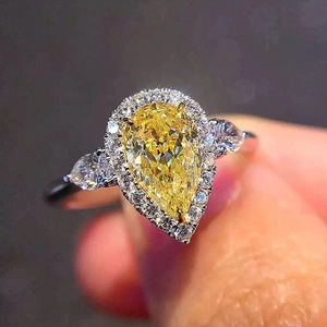 Pear cut yellow zircon halo ring with silver metal band and sparkling accent stones