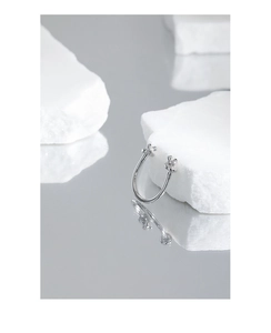 Macro detail of silver knot ring on white stone with reflection on dark background