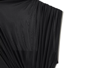 Macro detail of black sheer mesh fabric with elegant layered pleated texture