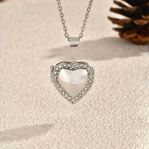 Detail of silver heart locket pendant with sparkling rhinestones and an opening frame