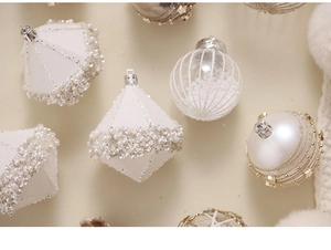 Close-up of champagne and white Christmas balls with glitter and pearl details