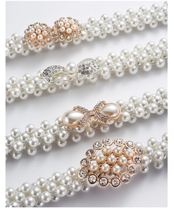 Detailed view of four elastic pearl belts with sparkling rhinestone flower buckles