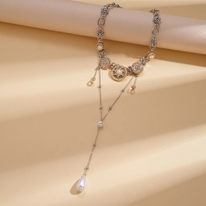 Close-up of vintage multi-layer tassel necklace with pearls and starburst relief pendants