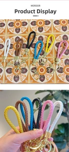 Detailed close-up of woven leather keychains in multiple colors with gold metal hardware