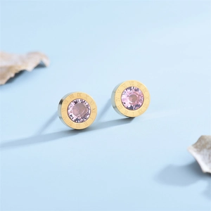 Macro view of rose gold roman numeral earrings with pink zircon stone inlay