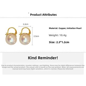 Détails de boucles d'oreilles pendantes en perles blanches et crochets en cuivre doré