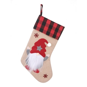 Christmas stocking with faceless gnome design and red buffalo plaid cuff on white background