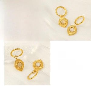 Macro shot of 18K gold plated hoop earring with sunburst opal pendant on white silk