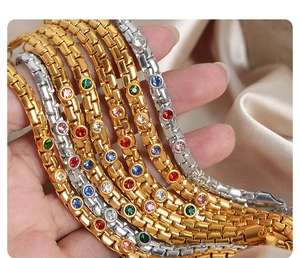 Macro view of gold and silver bracelets with colorful rhinestones on silk fabric
