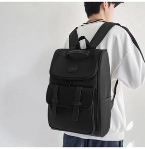Rear view of a black high-density nylon backpack with dual strap buckles on a model