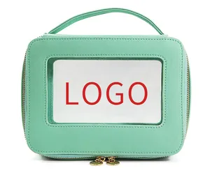 Detail of mint green textured makeup bag with clear PVC window and gold double zippers