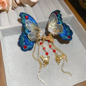 Vue détaillée des boucles d'oreilles papillon brodées avec cristaux et pampilles
