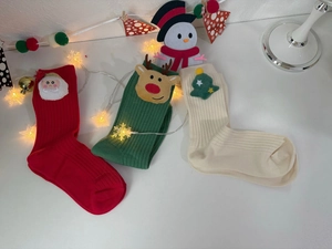 Detailed view of 3-pack Christmas socks with 3D Santa, reindeer, and tree ornaments