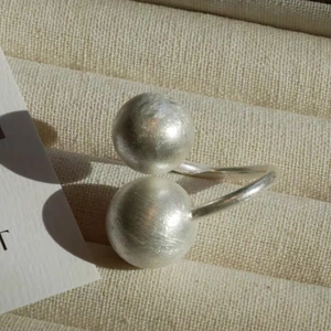 Gros plan sur une bague ajustable en argent avec billes sur écrin en velours