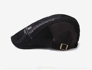 Detail of skull rivet and embroidered fashion slogans on black cotton beret cap