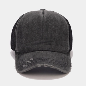 Macro shot of retro washed canvas trucker hat showing distressed brim and mesh panel