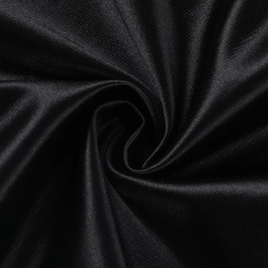 Gros plan macro sur le tissu en satin noir élégant avec des plis soyeux et brillants