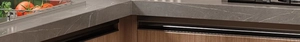 Detail of gunmetal pot lid rack on a grey quartz kitchen countertop with modern sink