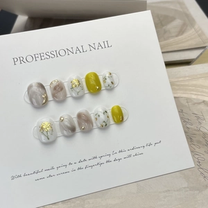 Handmade press-on nails with yellow finish, marble texture, and gold foil floral accents