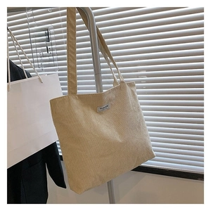 Detail of beige corduroy tote bag with Fashion label on a metal display rack
