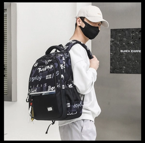 Detail of multi-pocket black and purple graffiti backpack showing street style layering