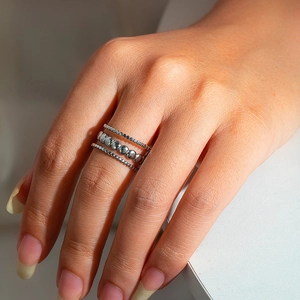 Close-up of stacked silver bead rings on a hand with soft natural lighting detail