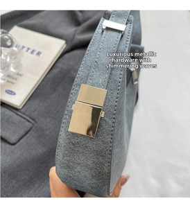 Detailed view of matte gray crescent bag with polished silver buckles and texture