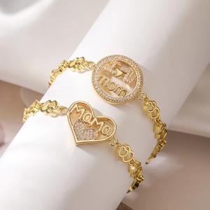 Detail of 18K gold-plated MOM bracelets with heart links and crystal mama charms