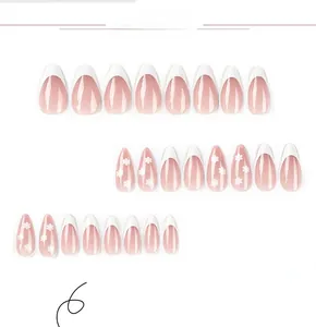 Detail of 24 white French tip almond press-on nails with delicate floral patterns