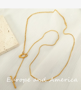 Close-up of gold OT toggle necklace with snake chain and paperclip link detailing