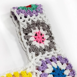 Detailed macro view showing the textured crochet stitches of a multi-color handmade knit bag