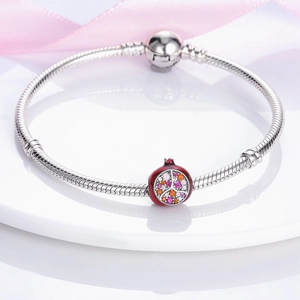 Detail of snake chain bracelet with red pomegranate charm and colorful zircons