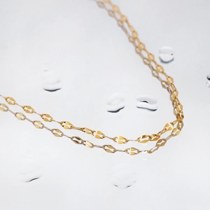 Minimalist gold plated oval link chain necklace shown on a clean water ripple background