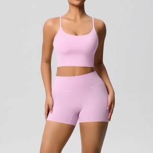 Detail of pink yoga set showing thin straps sports bra and high waist biker shorts texture