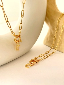 Detailed view of gold paperclip necklaces with diamond-encrusted K and C letter pendants