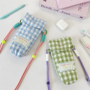 Close-up of sky blue and lime green quilted plaid camera bags with adjustable straps