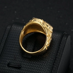 Detailed view of gold plated men's signet ring with rugged texture on black display