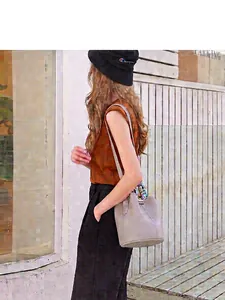 Genuine light grey leather bucket bag with decorative floral silk scarf on model